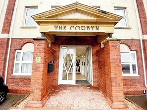 A building entrance with a sign reading 'THE CORBYN.'