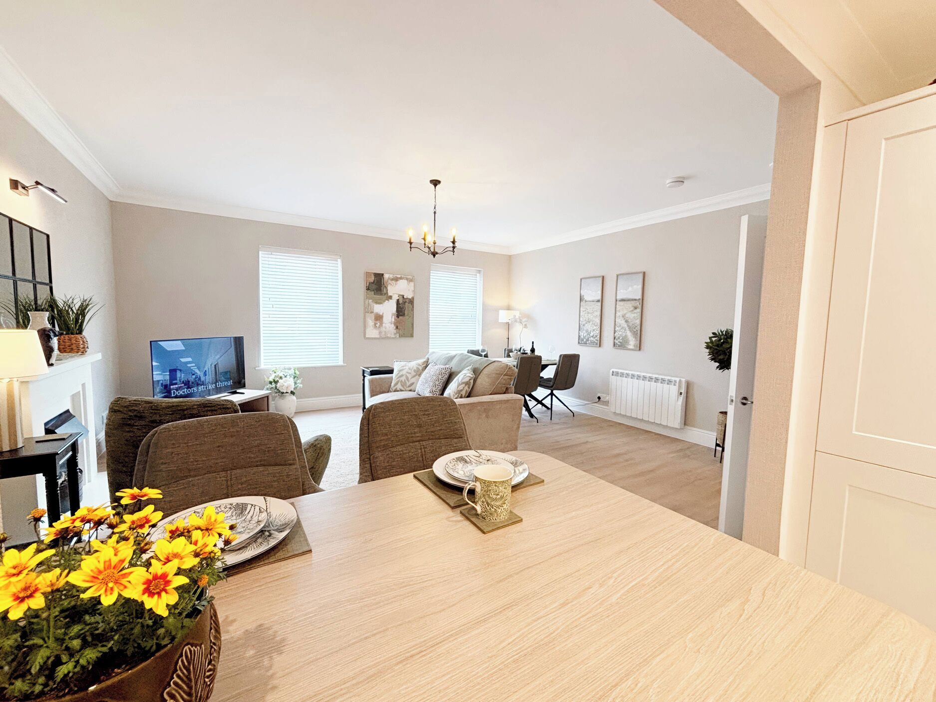 Uma sala de estar moderna com uma mesa de jantar, sofá e televisão.