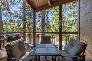 An outdoor deck with a table and chairs, a grill, and a view of trees. - Cozy Northstar Retreat Near Trails & Village (Truckee)