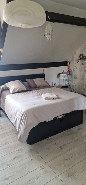 Ein Schlafzimmer mit Bett, Nachttisch, Lampe und Wanddekorationen.
