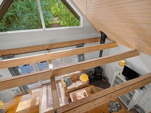 A multi-level wooden interior with a loft area, a sofa set, a table, and a fireplace. - "Zelda" - 275m from the sea by Interhome (Millinge)