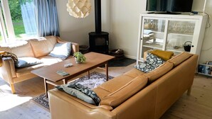 Una sala de estar con sofá, mesa de centro, televisor y chimenea.