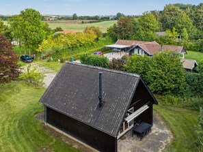 A rural property with a large barn, a covered outdoor seating area, and a view of the surrounding countryside.