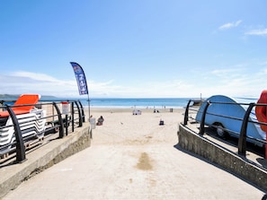 Ein Strand mit blauem Himmel, einer Flagge und einem Rettungsturm.