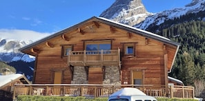 A wooden chalet with a balcony, stone accents, and a mountain backdrop. - Balcony, tv, 30m², Pralognan-la-Vanoise (Pralognan-la-Vanoise)