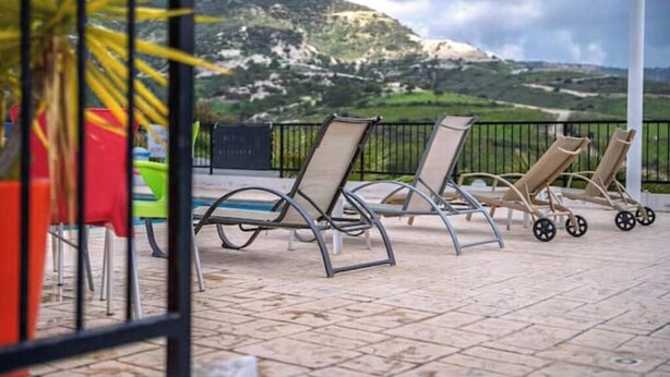 Una terrazza con poltrone, un tavolo e vista su un paesaggio montuoso.