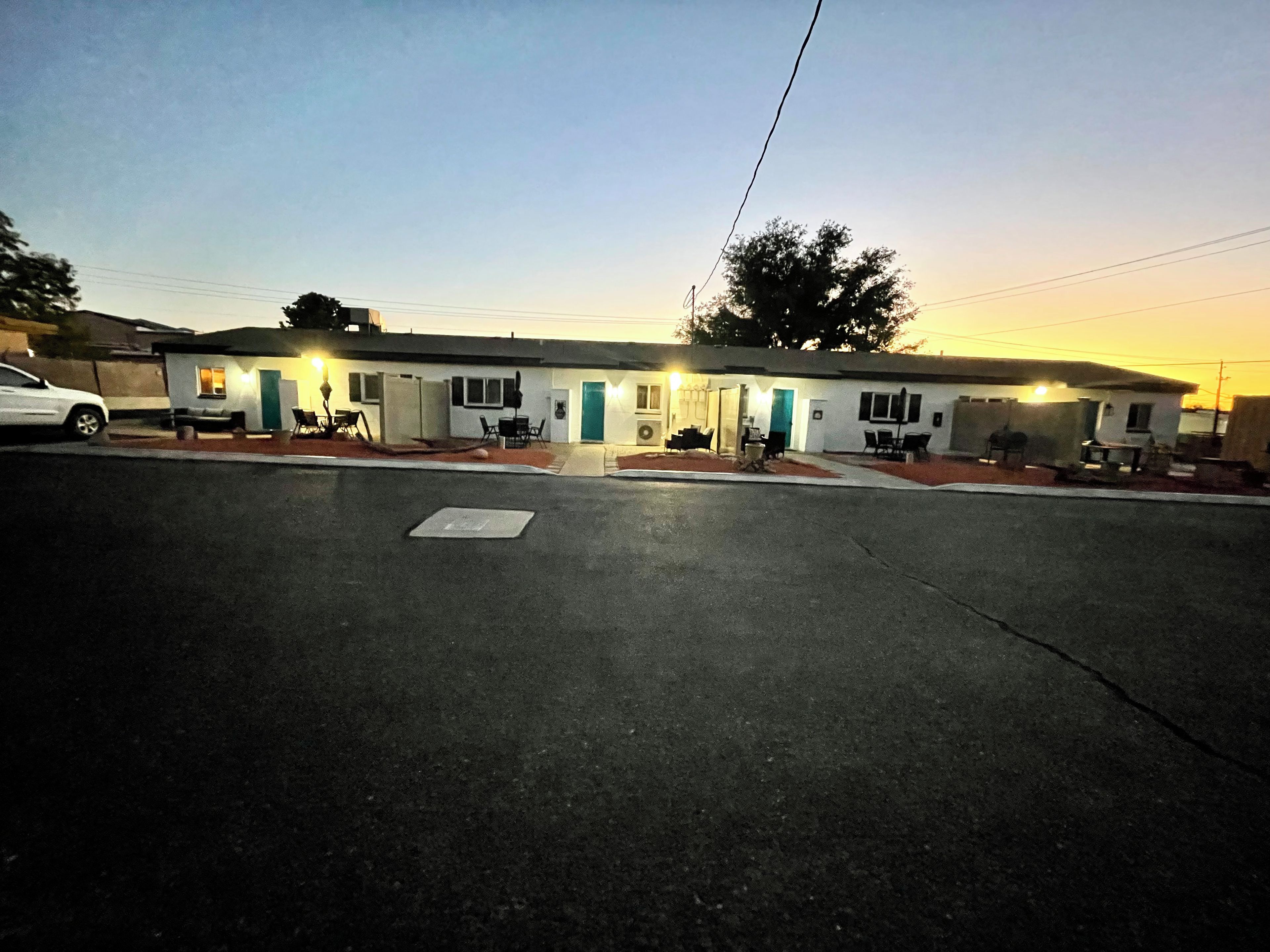 A motel with a central entrance, multiple rooms, and a parking area.