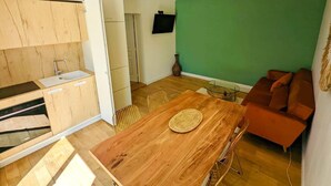 A compact living space with a kitchenette, dining area, and seating.