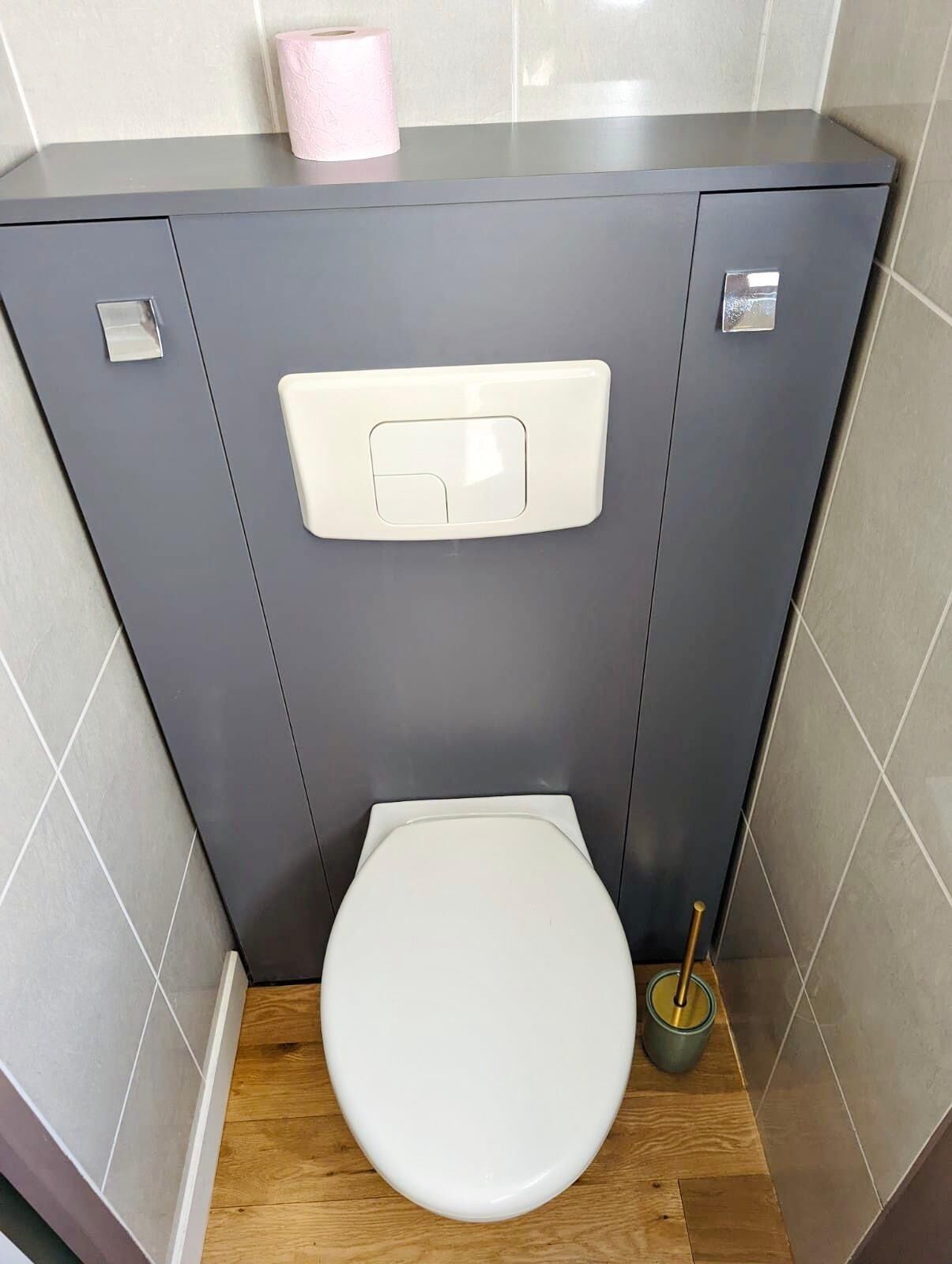 Un baño moderno con inodoro, bidé y dispensador de papel higiénico.