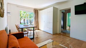 A modern living room with a sofa, dining table, and chairs.