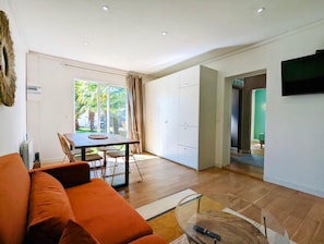 Una sala de estar moderna con sofá, mesa de comedor y sillas.