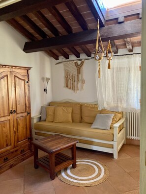 Ein gemütliches Wohnzimmer mit einer Holzsofa, einem Holztisch und einer dekorativen Wandweberei aus Makramee.