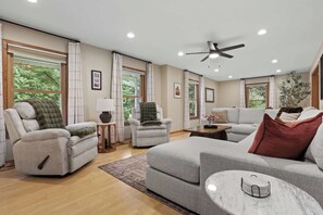 A spacious living room with a sofa, armchairs, a coffee table, and a ceiling fan. - Heated Pool - Hot Tub - Sauna - Game Room - Pets (Sun Prairie)