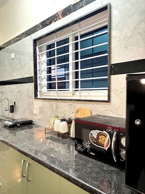 A kitchen with a window, a toaster, and a coffee maker. - Luxury Stay 20 mins away from Airport! (Bengaluru)