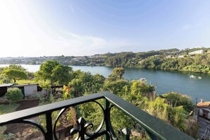 A river with a view of a town and greenery. - Waterfront Villa by Douro w/ BBQ & River Views (Avintes)
