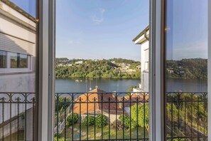 A balcony with a view of a lake, buildings, and greenery. - Waterfront Villa by Douro w/ BBQ & River Views (Avintes)