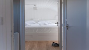 Ein Schlafzimmer mit einem Bett, einem Deckenventilator und Holzboden.