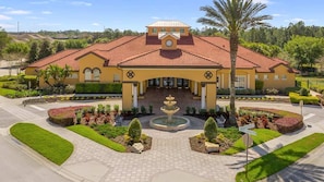 A large building with a tiled roof, a central fountain, and landscaped gardens. - Disney Themed Resort Home With Lake View (Kissimmee)
