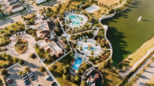 An aerial view of a resort with multiple swimming pools, a golf course, and a lake. - Resort Home With Pool Spa Game Room Near Disney (Kissimmee)