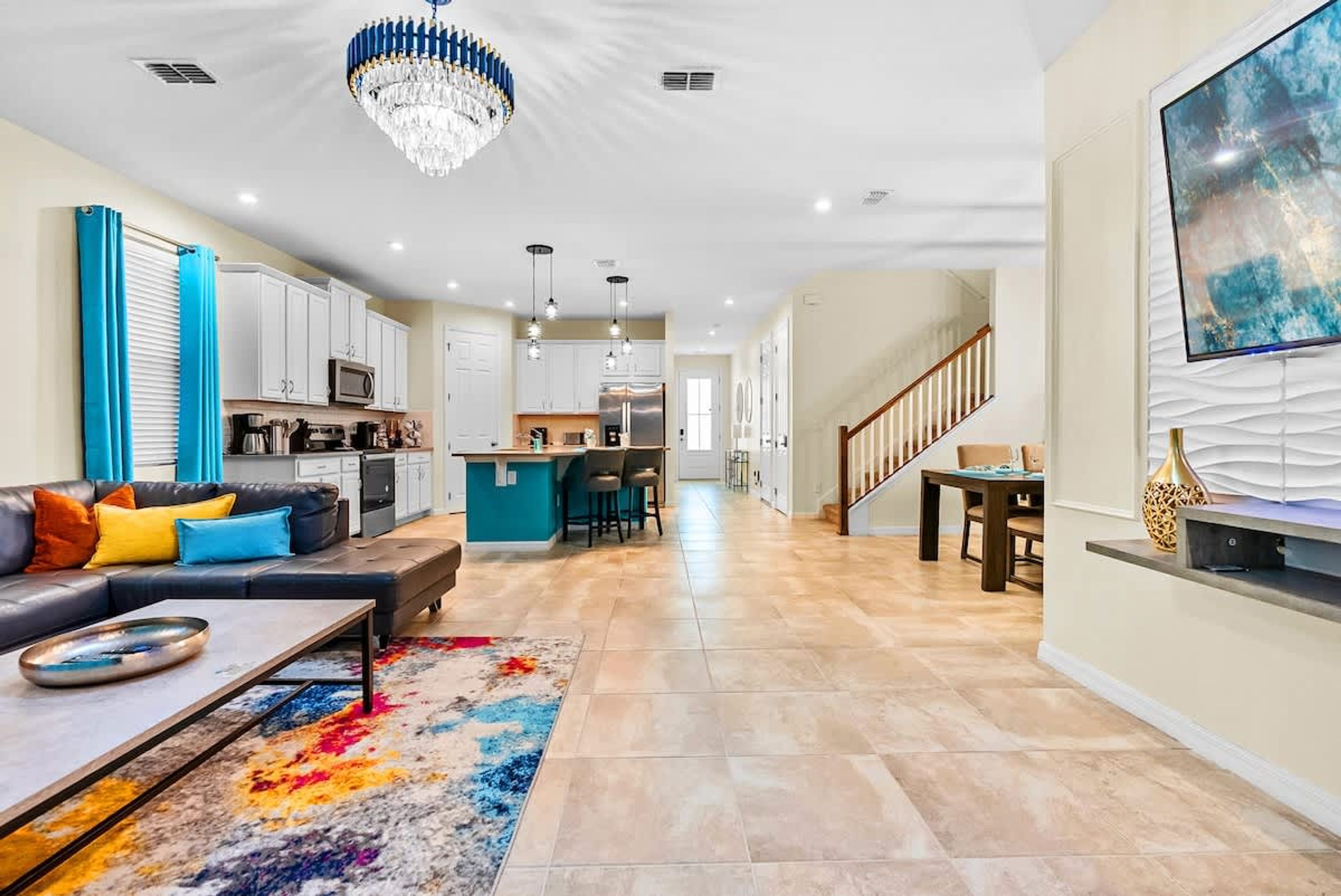 A modern living room with a sofa, coffee table, and a colorful rug.