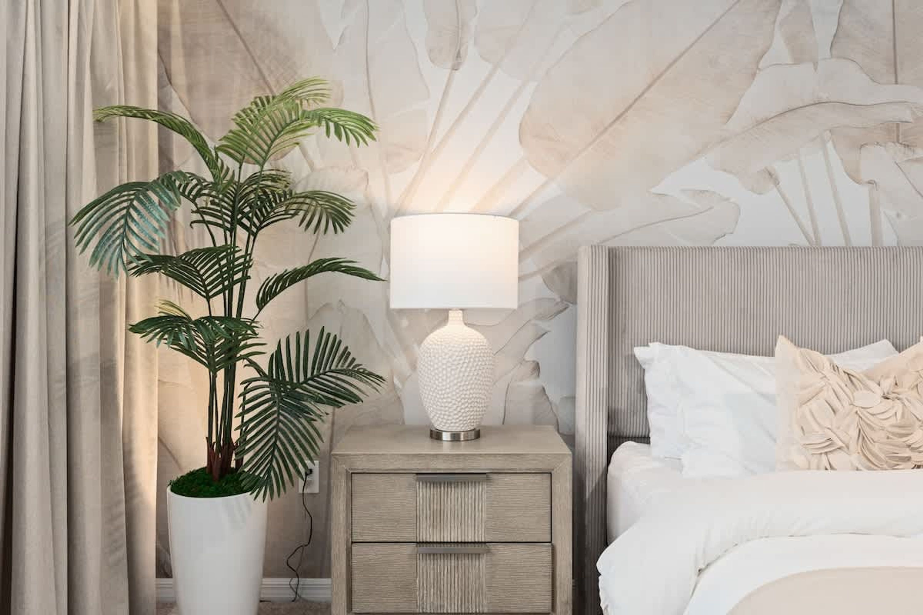 Et soveværelse med en seng, et natbord med en lampe, en potteplante og en væg med et struktureret design.