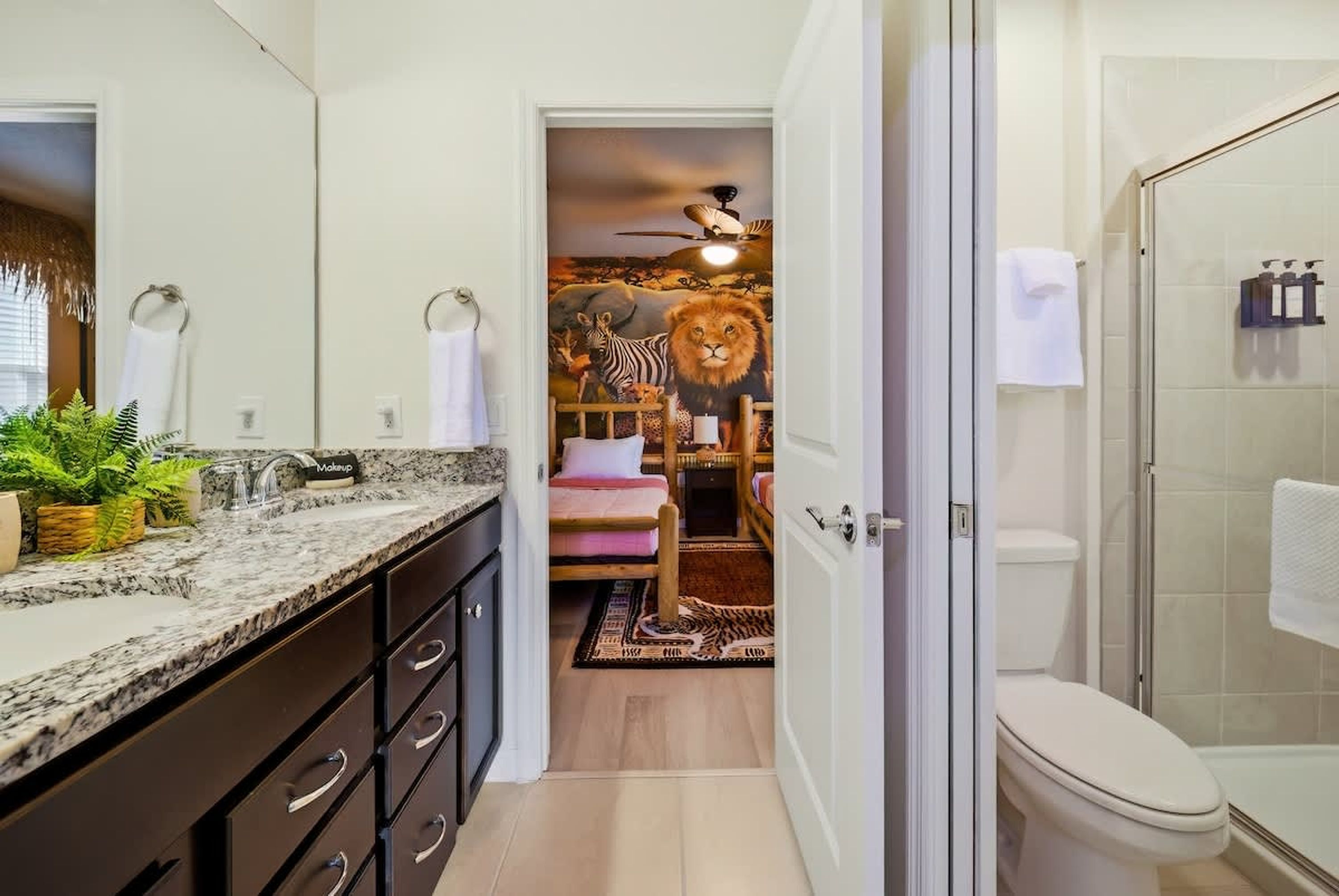 A bathroom with a shower, toilet, and a mirror.