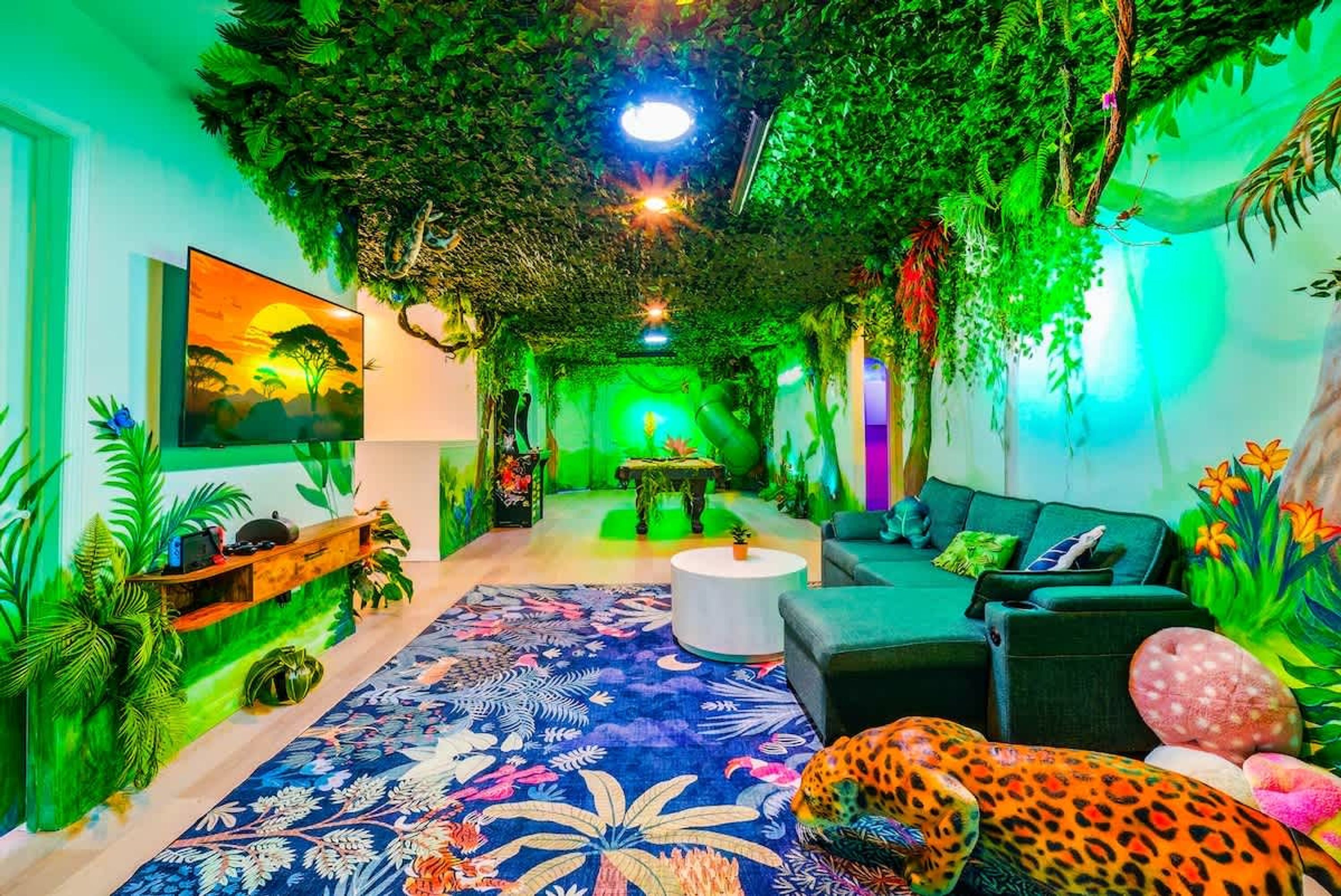 Una habitación con un sofá, un peluche de leopardo, un tapete estampado y un cuadro de una puesta de sol.