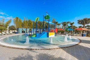 A water play area with a circular pool, a climbing structure, and lounge chairs around the pool. - Windsor Resort Private Pool Theater Game Room (Davenport)