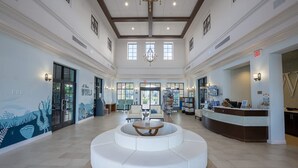 A spacious lobby with a central seating area, a reception desk, and a mural depicting underwater scenes. - Resort Home Private Pool and Spa Outdoor Theater (Kissimmee)