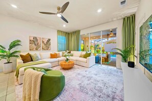Ein modernes Wohnzimmer mit einer Sofagarnitur, einem Couchtisch und einem Deckenventilator.