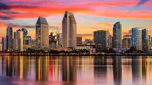 A city skyline with high-rise buildings, a waterfront, and a sunset sky. - Peaceful 1-bedroom recreational vehicle with AC in Spring Valley (Spring Valley)