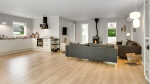 A modern living space with a kitchen, dining area, and a fireplace. - "Adisl" - 300m to the fjord by Interhome (Højslev)