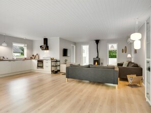 Ein stilvoller Wohnraum mit Küche, Essbereich und Kamin.