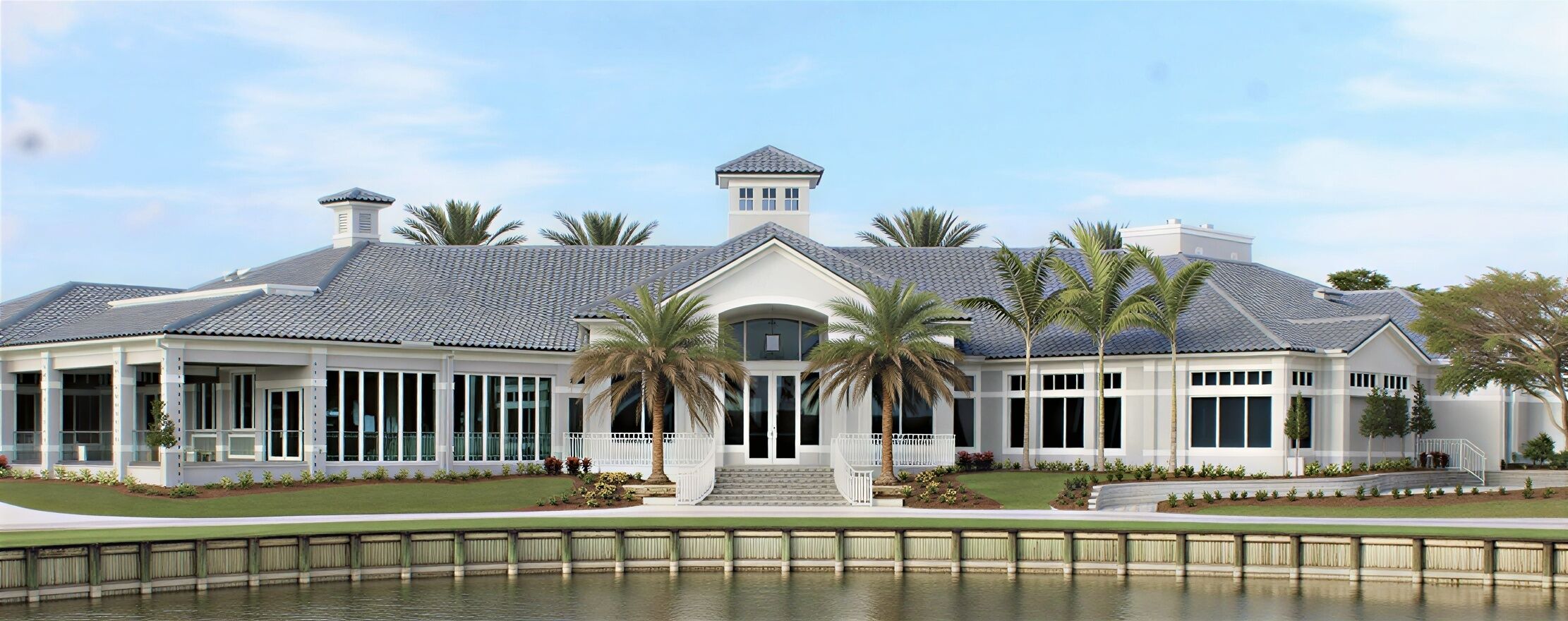 A large, single-story house with a wrap-around porch, a central entrance, and a small tower-like structure on the roof.