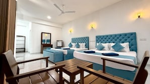 A hotel room with two beds, a ceiling fan, and a small table.
