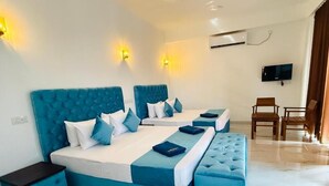 Una habitación de hotel con una cama grande, una mesita, una silla y un televisor.
