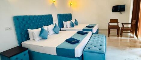 Una habitación de hotel con una cama grande, una mesita, una silla y un televisor.