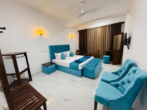 A modern hotel room with a bed, a sofa, a chair, a desk, and a TV. - The Ceylon Charm - Mirissa (Mirissa)
