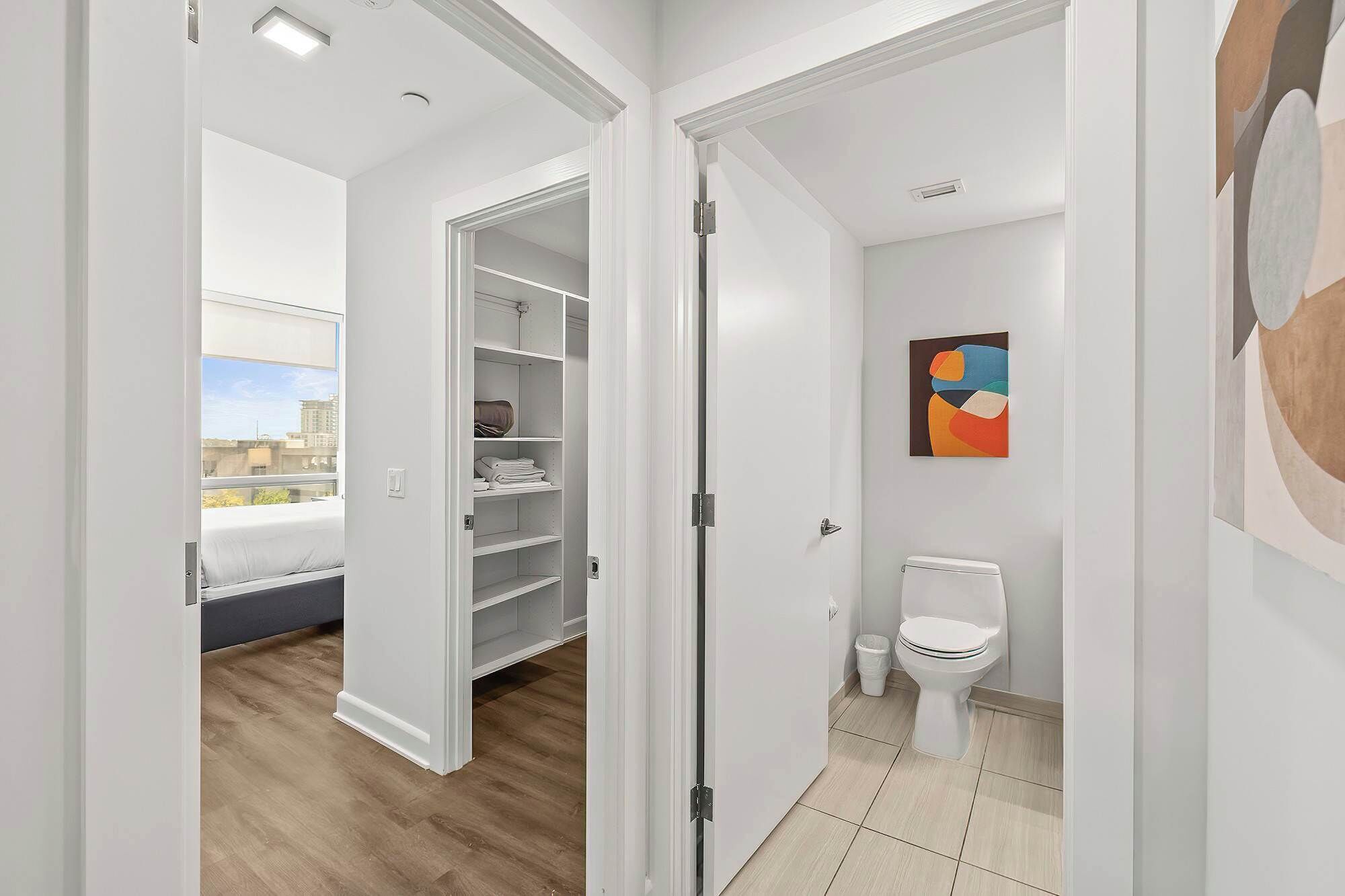 Um apartamento moderno com closet espaçoso, banheiro completo e vista para a cidade.