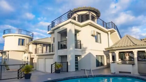 Un grand immeuble à plusieurs étages, avec une piscine en premier plan.