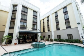 A hotel with a swimming pool, outdoor seating, and a covered patio area. - Bright & Comfortable Room w/ Cloud Nine Bed–Minutes from Boca Attractions (Boca Raton)