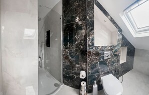 A modern bathroom with a glass-enclosed shower, a toilet, and a sink with a marble backsplash. - West Kensington Studio King Bed 5 Min to Tube (London)