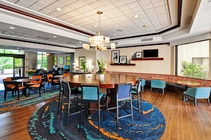 A spacious lobby with a round table, seating arrangements, and a large window. - Ideal Guestroom for Short Stays–Conveniently Located Near Boca Attractions (Boca Raton)