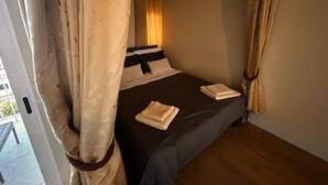 A bedroom with a bed, curtains, and a window.