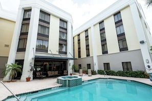A hotel with a swimming pool, outdoor seating, and a covered patio area. - Boca Raton Unit w/ Free Breakfast, Parking & Onsite Heated Pool (Boca Raton)