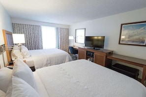 A hotel room with two beds, a desk, a television, and a painting on the wall. - Boca Raton Unit w/ Free Breakfast, Parking & Onsite Heated Pool (Boca Raton)