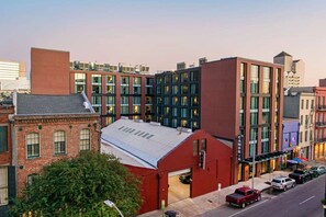 Un edificio de varios pisos con fachada roja, ventanas grandes y techo plano.
