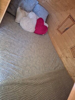 A room with a patterned carpet, a wooden wardrobe, and a bed with a white and red pillow. - Vrbo Property (Rahon)