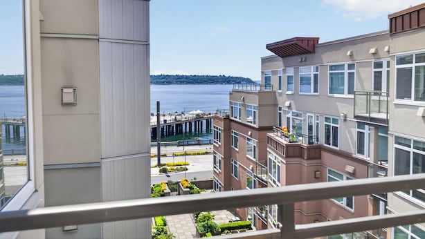 A high-rise building with a view of a waterfront and a pier. - Welcome to Baby Mars: The Ultimate Waterfront Base (Seattle)