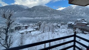 A snowy mountain landscape with buildings in the foreground.